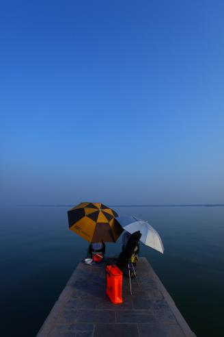 《蓝天下的垂钓客》每天，柳叶湖边都会有这样的垂钓客。对于垂钓者来说，撑上小伞，手把鱼竿，坐在湖边享受他们不一样的乐趣。.JPG